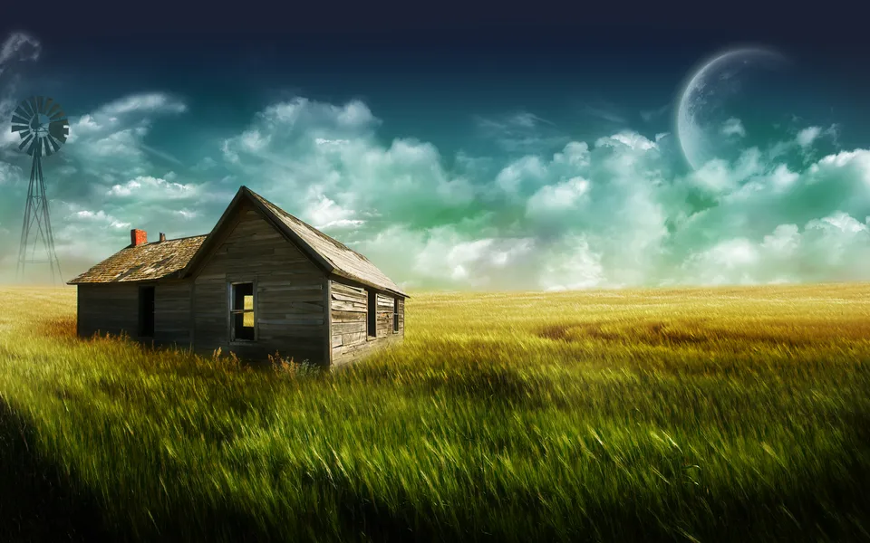An old wooden farmhouse sits in a field of tall grass with a windmill in the distance under a dramatic sky.