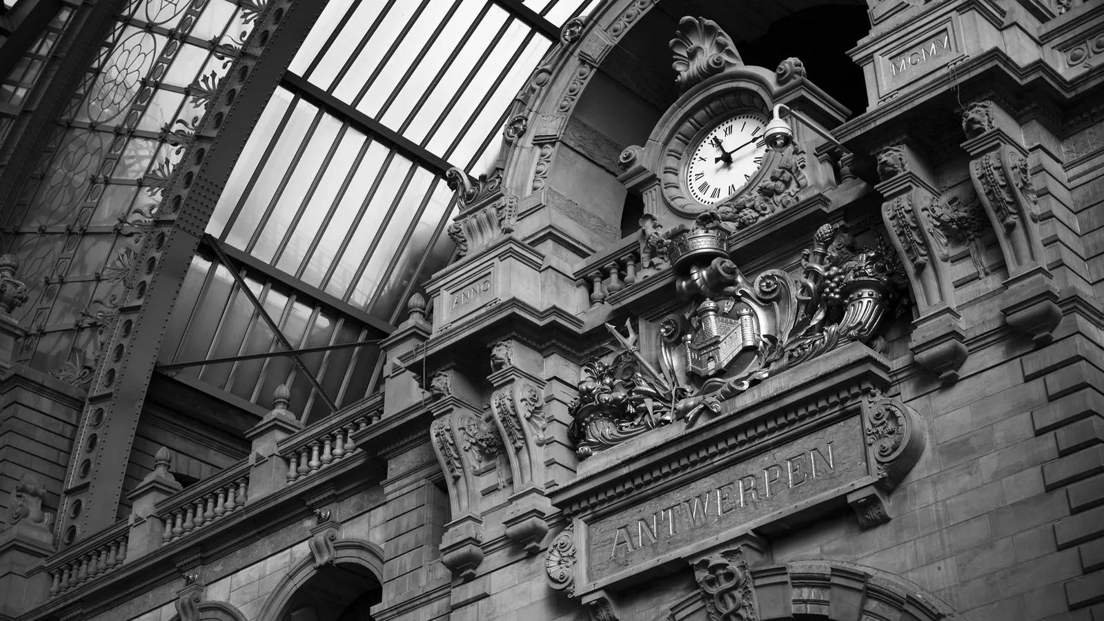 Close-up of the ornate clock and architectural details at Antwerpen Central Station.