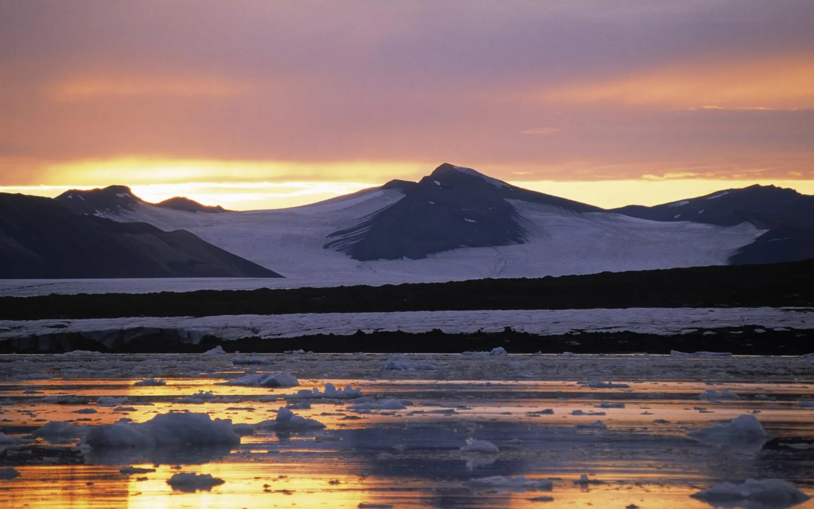A serene arctic landscape at sunrise, with snow-capped mountains reflecting in the water dotted with ice floes.