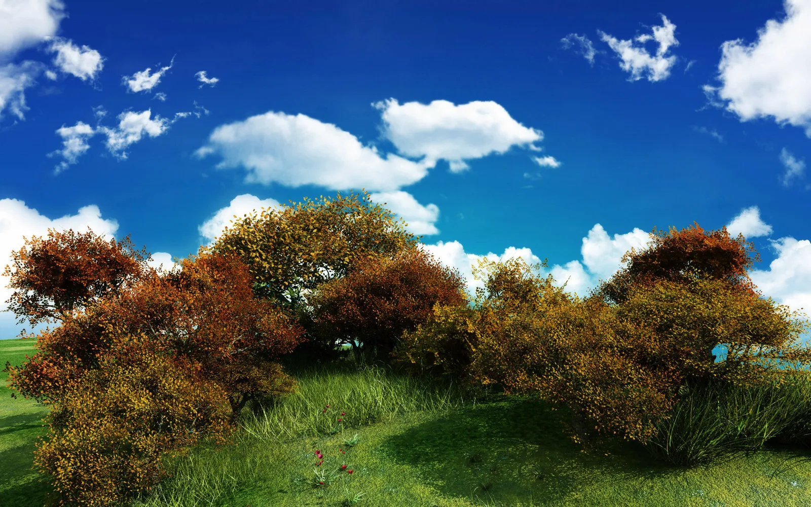 A vibrant hillside covered in green grass and trees displaying red and yellow autumn foliage under a bright blue sky.