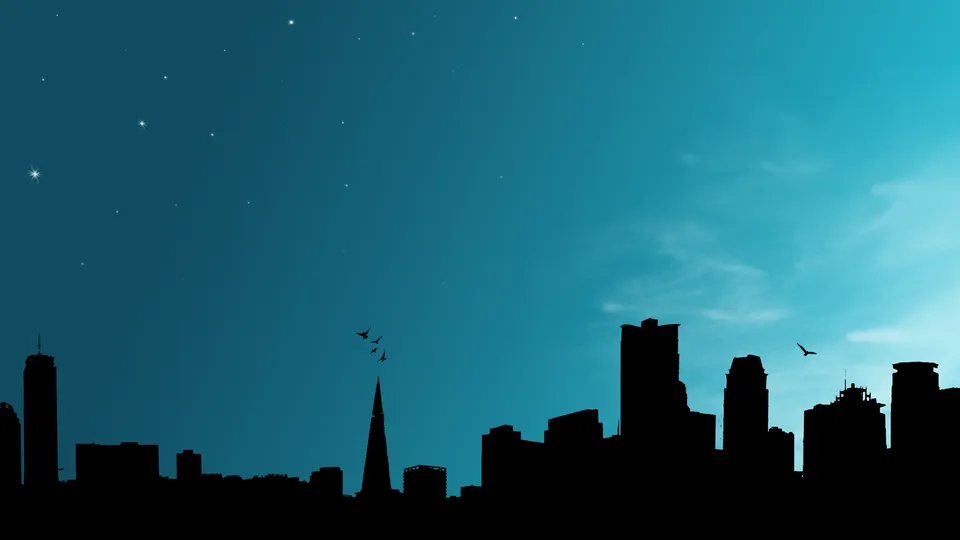 Silhouette of a city skyline against a dark blue sky with stars and a few wispy clouds.