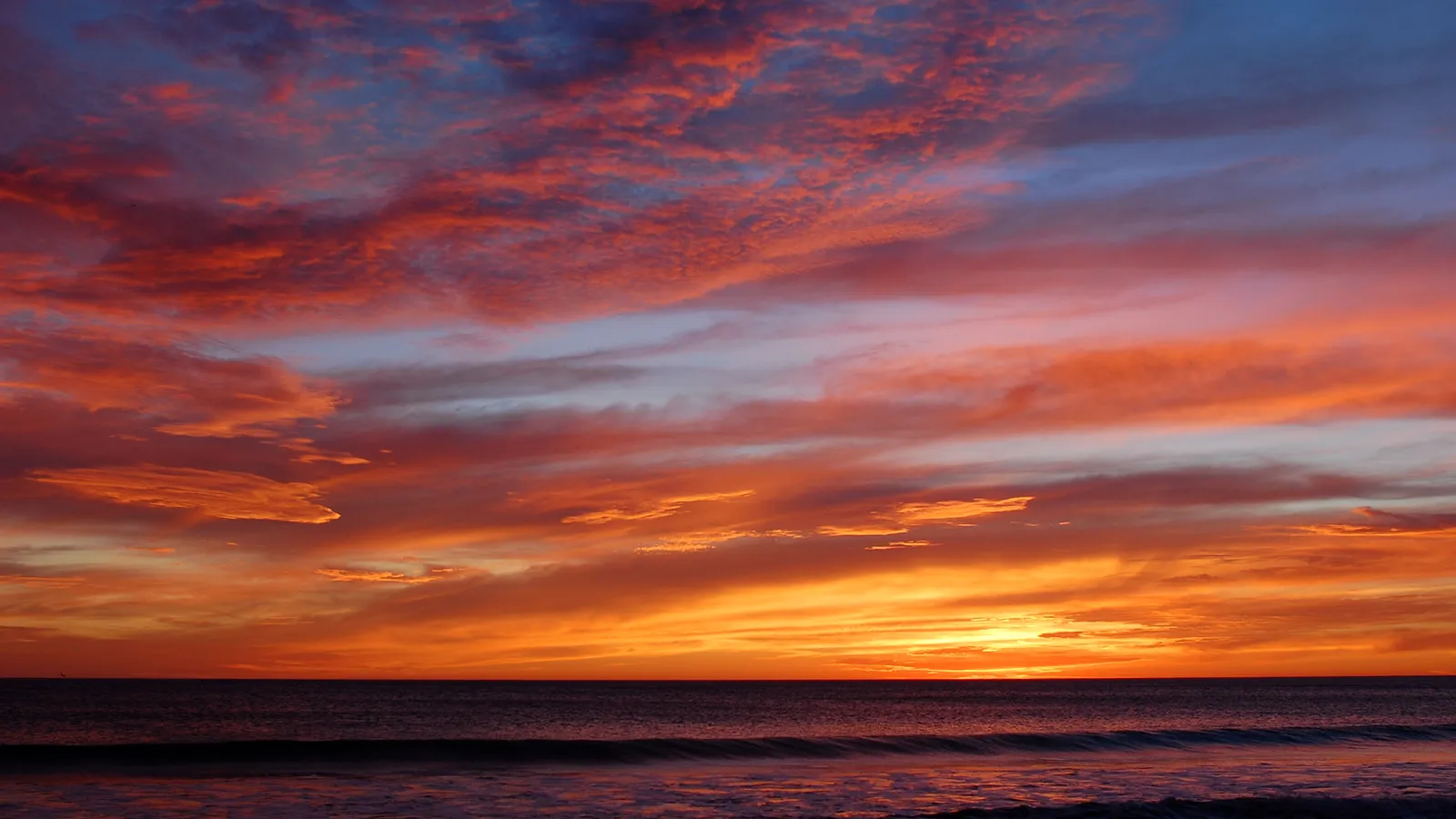 The sky is ablaze with vibrant pink, orange, and purple clouds at sunset.
