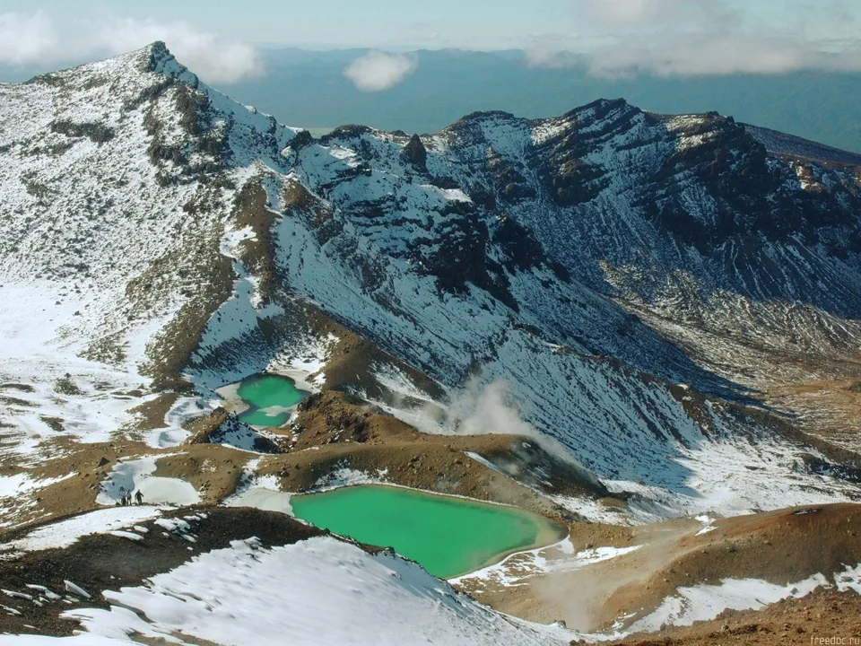 A high-angle view of vibrant turquoise lakes nestled in a snow-dusted mountain landscape.
