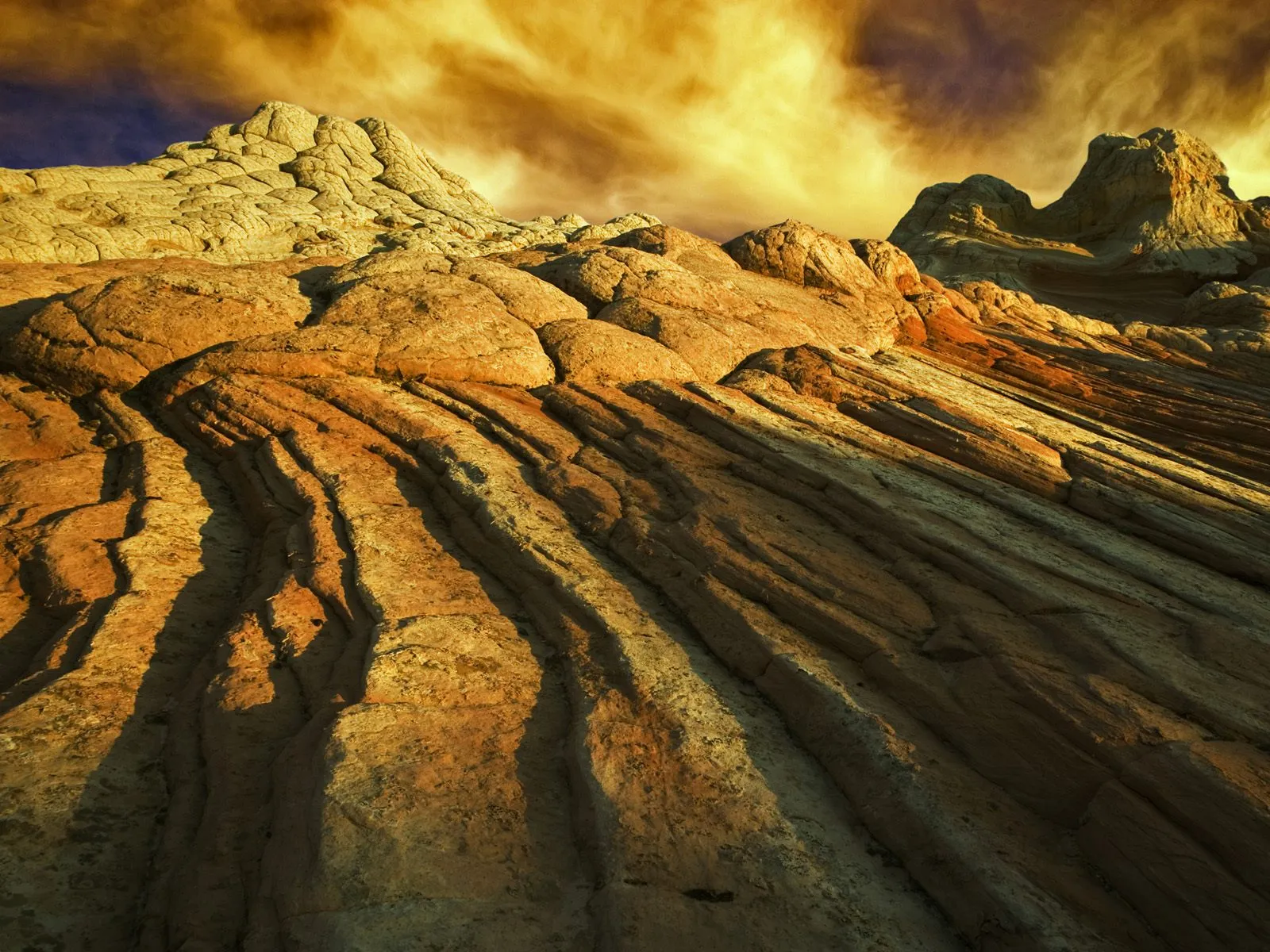 Close-up view of swirling sandstone rock formations illuminated by golden hour light.