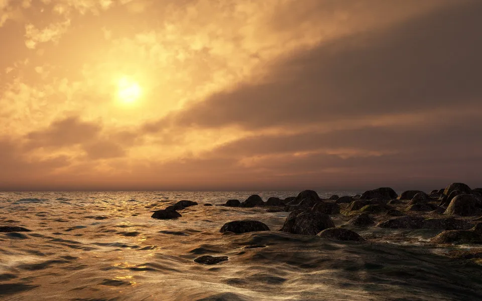 A bright sun sets over the ocean, casting golden light on choppy waves and a rocky shore.