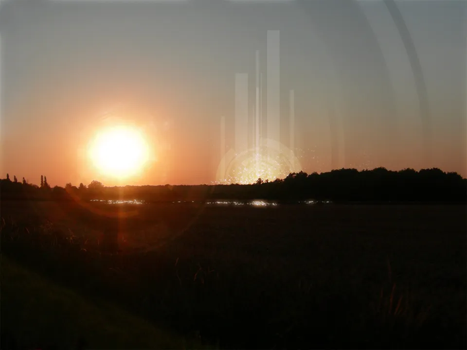 A bright sun sets over a dark field and trees, casting a golden glow.