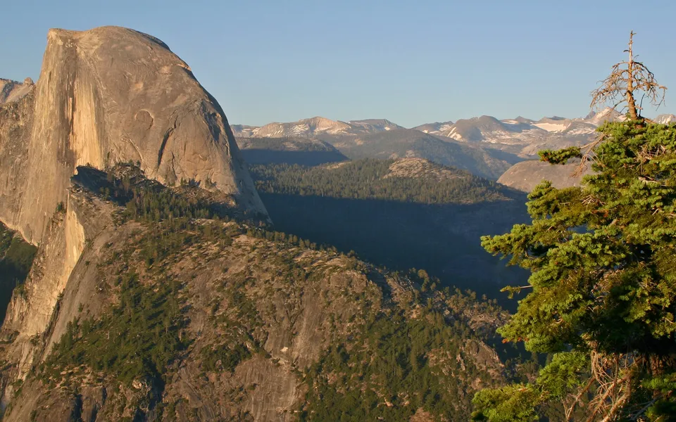 A view of Half Dome in Yosemite National Park bathed in the warm light of the setting sun.