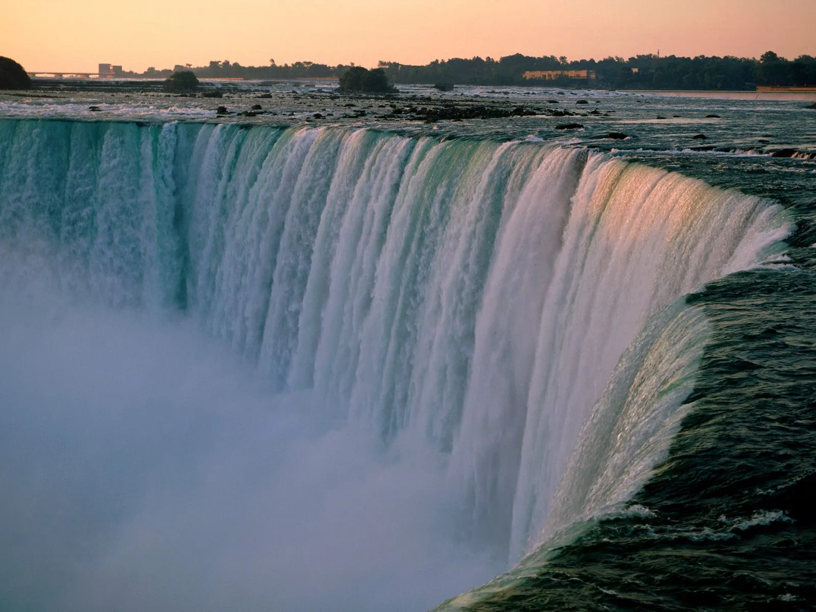 A wide view of Horseshoe Falls with water cascading over the edge into mist below.