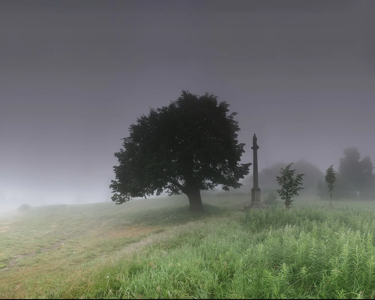 A solitary tree and a stone monument stand in a misty, grassy field under a dark sky.