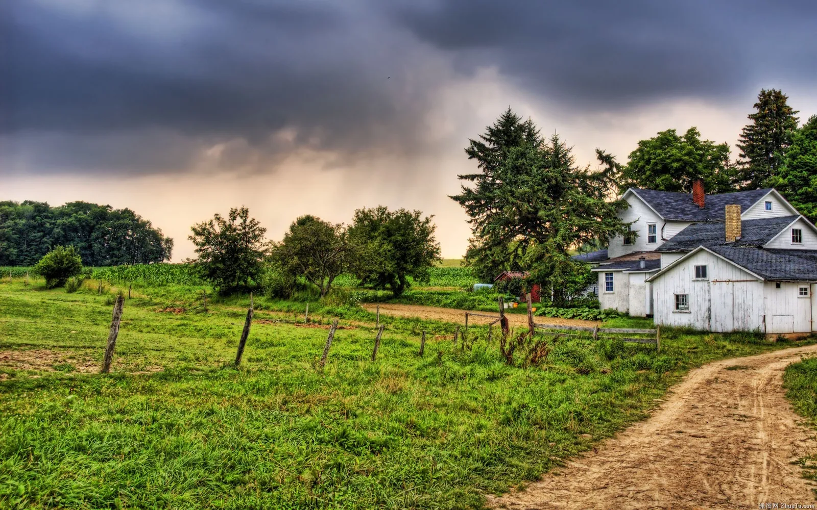 A dirt path leads to a white farmhouse under dark, dramatic storm clouds.