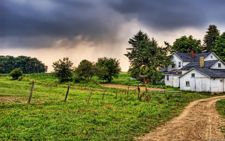 A dirt path leads to a white farmhouse under dark, dramatic storm clouds.