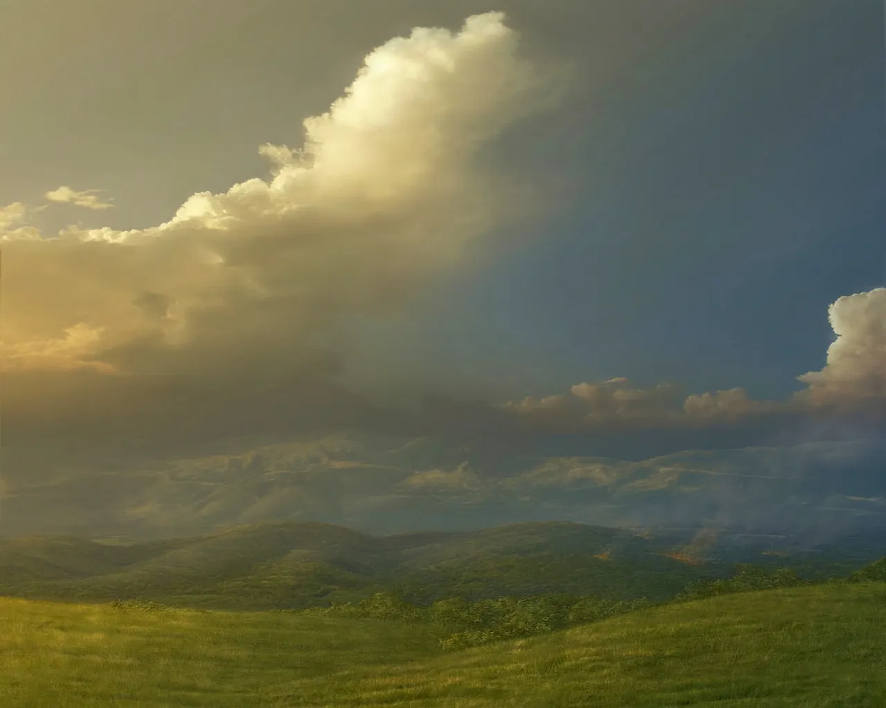 A vast landscape with rolling green hills under a dramatic sky filled with storm clouds and golden light.