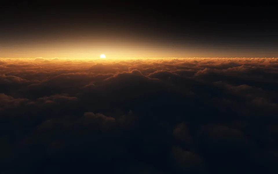 The sun is setting just above a vast expanse of clouds, casting a warm golden glow.