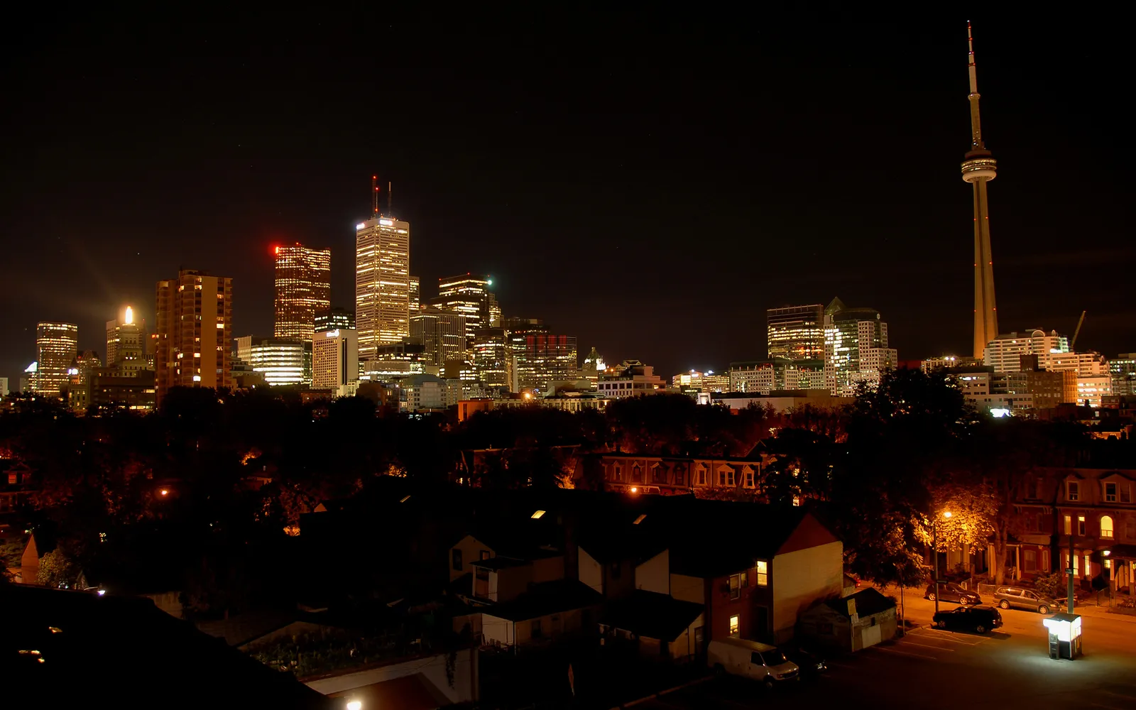 A nighttime view of the Toronto skyline, featuring the CN Tower and illuminated skyscrapers.