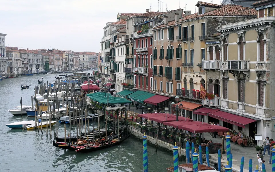 A view of the Grand Canal in Venice, with gondolas docked and historic buildings lining the waterway.